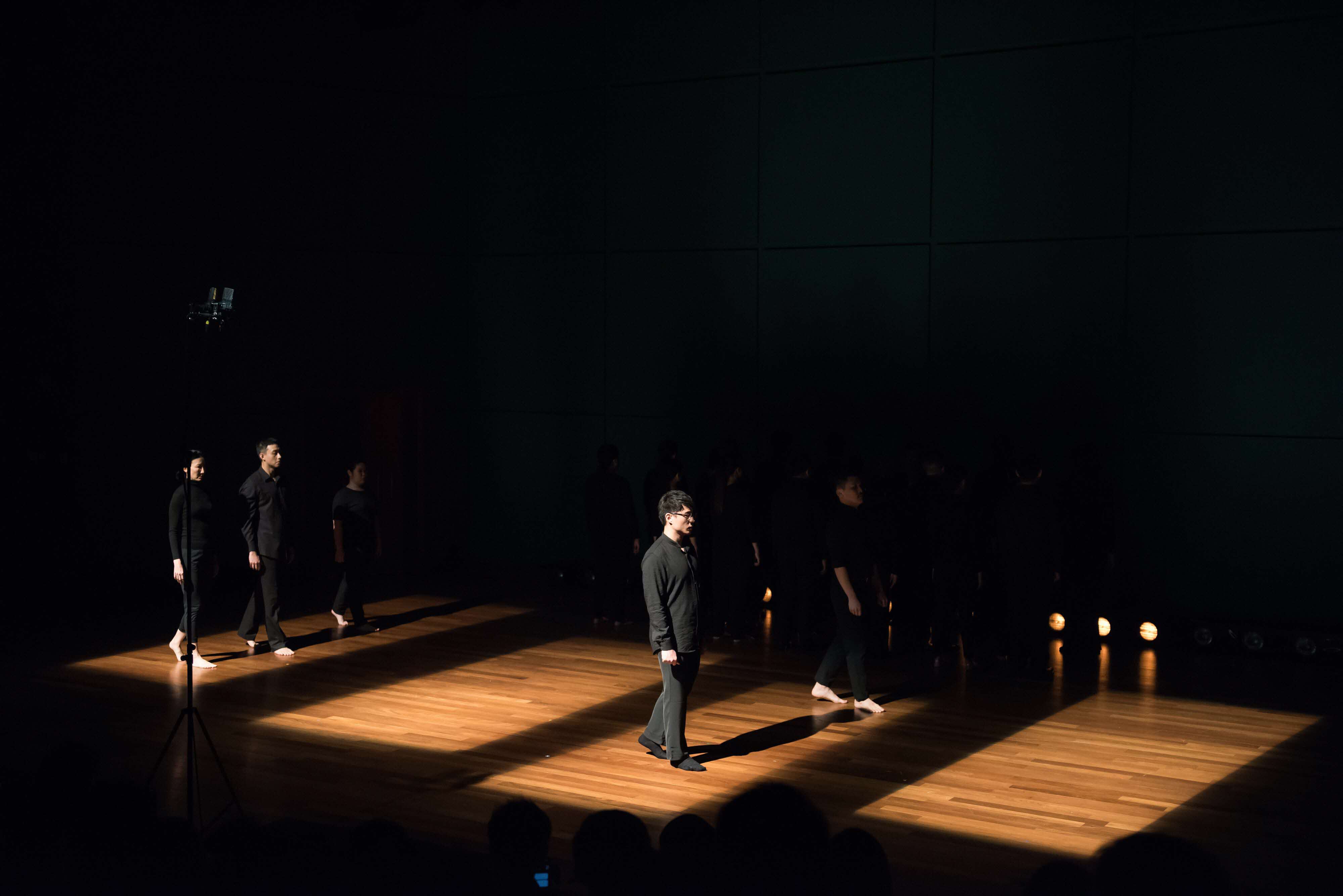 Performers dressed in formal all-black attire step into squares of light and shadow.  Beyond Music: Singapore Youth Choir Ensemble Singers Explore the Visual and Aural World