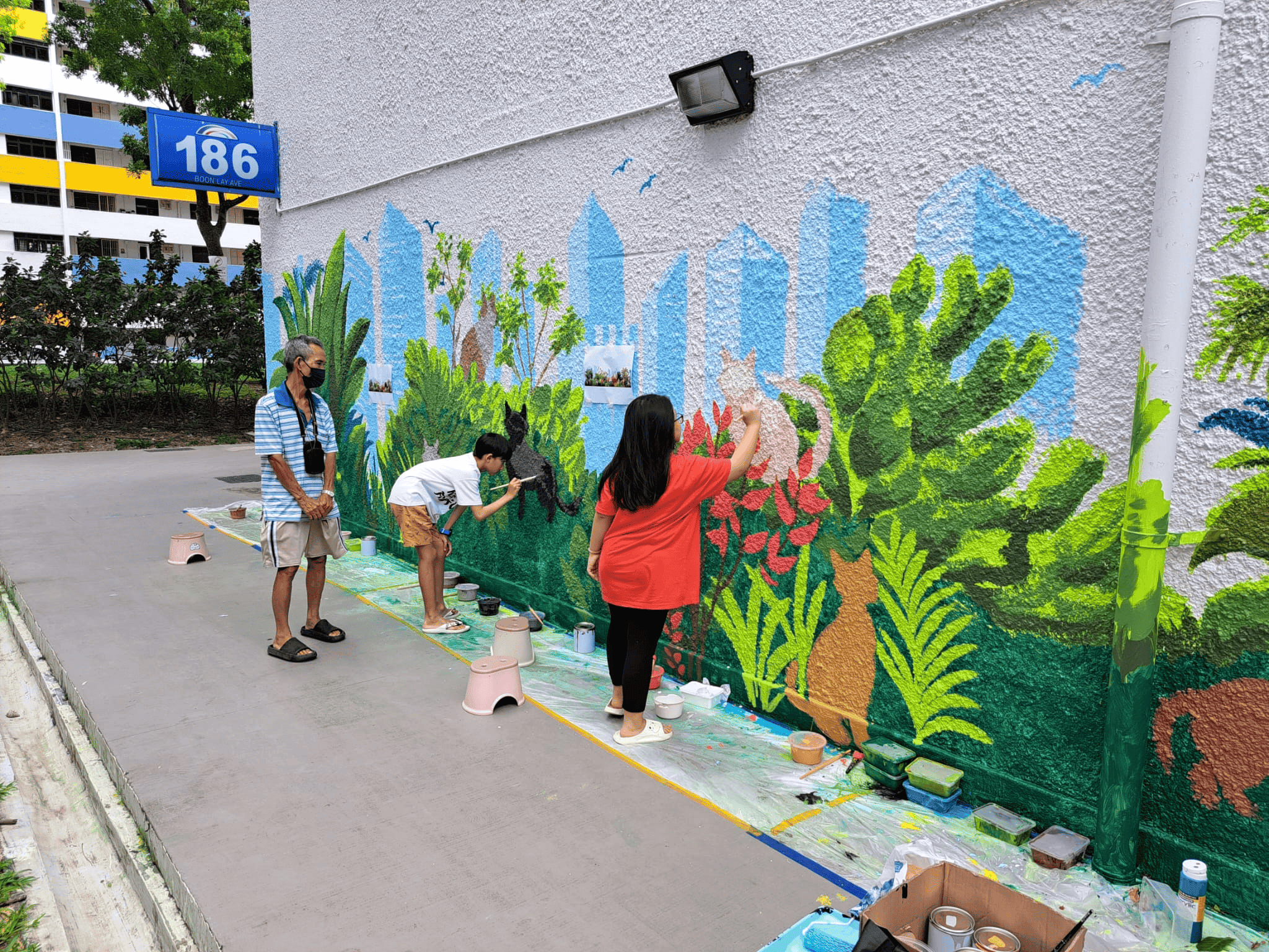 Volunteers painting mural of cats