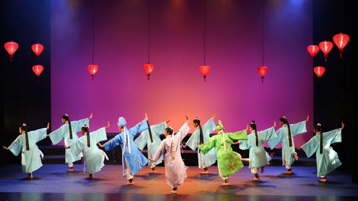 A dance sequence with performers in colourful traditional Chinese robes under red lanterns.  "Butterfly Lovers": A Timeless Tale Reimagined Through Generations